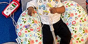 Lafenis Owens joined the competition — help win amazing prizes! baby, infant, medical_equipment, breathing_tube, pillow, floral_pattern, carpet, sneakers, black_pants, white_shirt, bib, face, child, lying_down, indoors, healthcare, monitor, cable, footwear, person