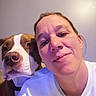 Pogo a rejoint le concours — aidez-le/la à gagner de superbes lots ! woman, person, dog, pet, selfie, portrait, face, smiling, indoors, home, close_up, brown_and_white, short_hair, collar, white_shirt, friendship, companion, animal, candid, purple_lighting