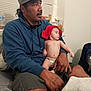 Jesse is registered to the contest to win money with this photo: man, baby, diaper, cap, blue_hoodie, indoor, window_blinds, water_bottle, snacks, bed, blanket, curious, holding, casual_clothing, facial_hair, skin, person, seated, home, relaxed