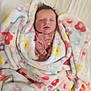 newborn, baby, blanket, sleeping, floral_pattern, soft_texture, cozy, infant, wrapped, cute, peaceful, indoors, bed, child, person, pink_clothing, resting, toddler, warm, portrait