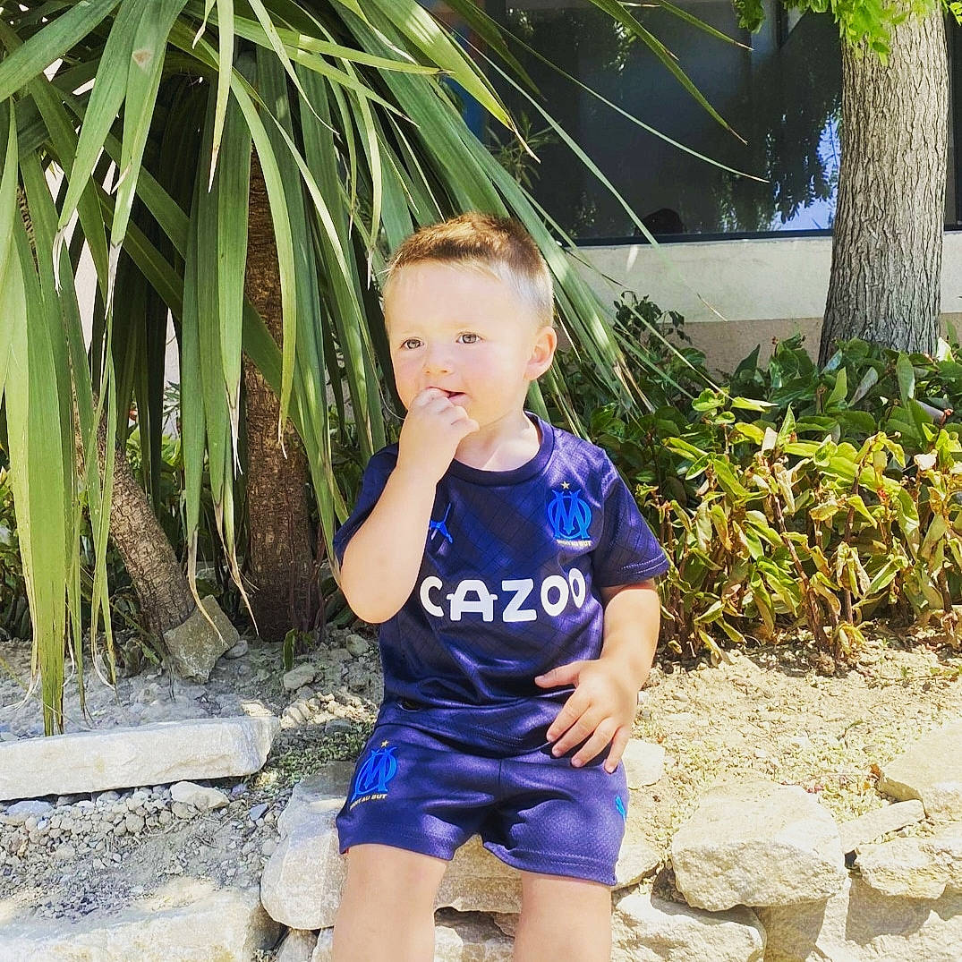 Hugo participe au concours pour gagner de l'argent avec cette photo : arecales, baby_toddler_clothing, child, electric_blue, fun, garden, grass, hairstyle, happy, leisure, people_in_nature, person, plant, sitting, t_shirt, terrestrial_plant, thigh, toddler, tree, vacation