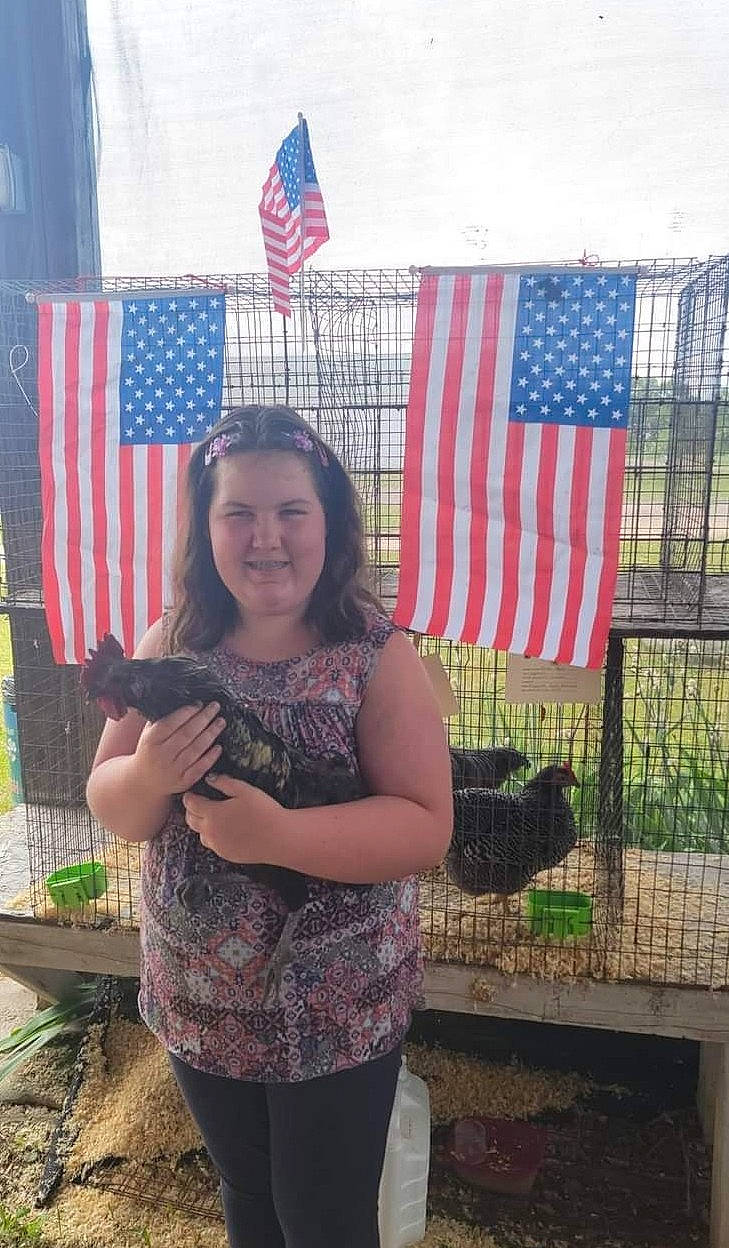 Della is registered to the contest to win money with this photo: event, fence, flag, flag_day_usa, flag_of_the_united_states, fun, grass, happy, jewellery, joy, leisure, luggage_and_bags, pattern, person, plant, recreation, smile, soil, textile, tree