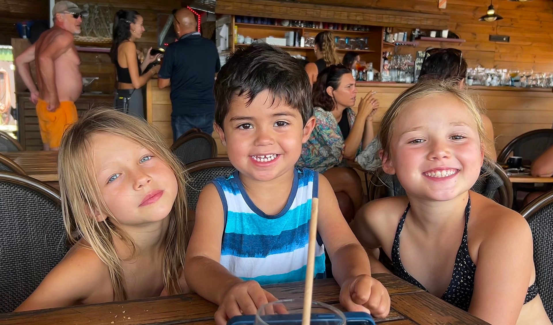 Hayden participe au concours pour gagner de l'argent avec cette photo : child, smiling, girl, boy, table, restaurant, indoor, wooden_interior, people, happy, casual, tank_top, swimsuit, friends, portrait, face, hair, chair, background, cafe