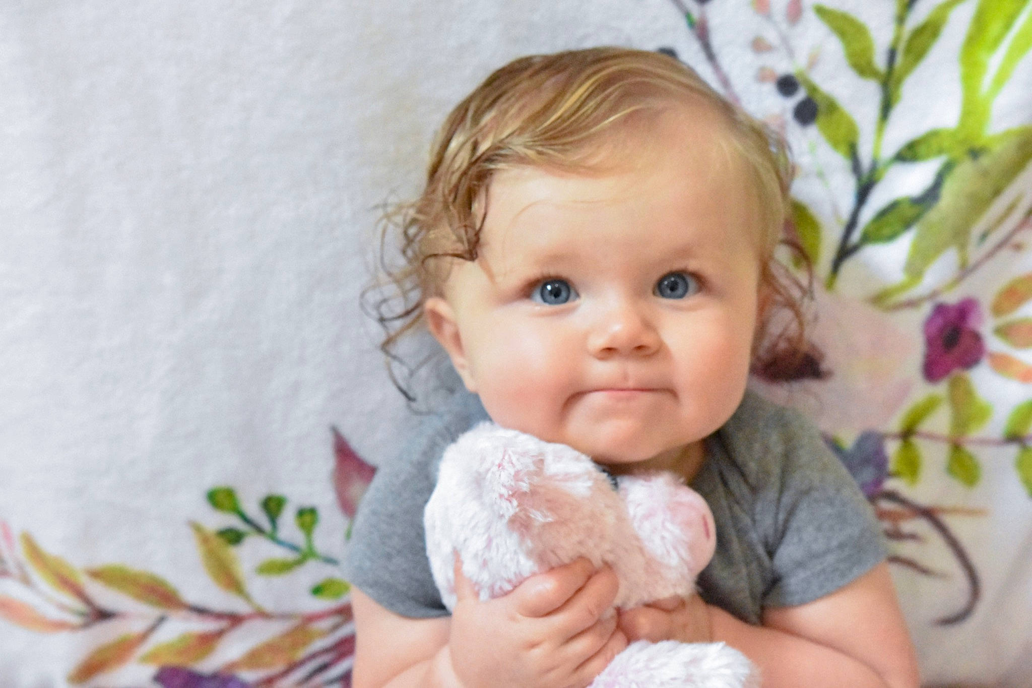 Sloane is registered to the contest to win money with this photo: baby, baby_products, baby_toddler_clothing, blond, cheek, child, comfort, eye, finger, fun, gesture, hand, happy, iris, lip, person, room, skin, smile, teddy_bear