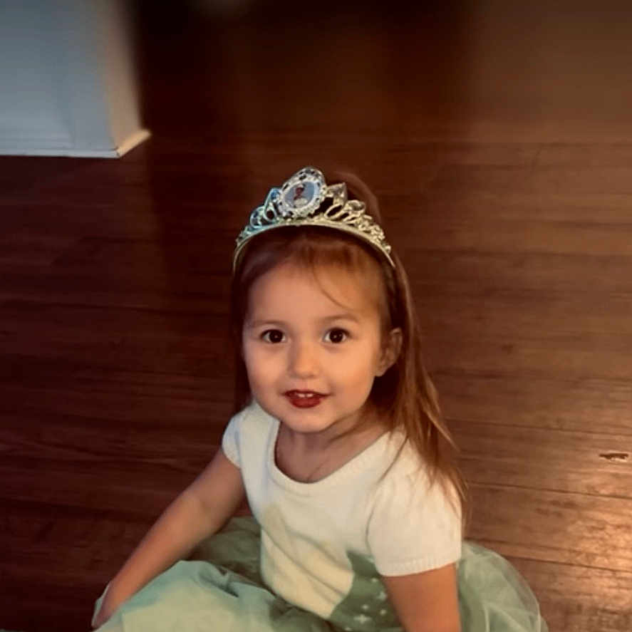 Emrie is registered to the contest to win money with this photo: accessories, advertisement, bodypart, child, clothing, dress, eveningdress, face, female, finger, formalwear, girl, hardwood, head, jewelry, person, photography, portrait, tiara, wood