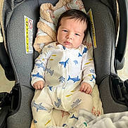 Lían Steven joined the competition — help win amazing prizes! baby, infant, car_seat, onesie, shark_pattern, blanket, clothing, face, person, indoor, child, cute, newborn, seat, fabric, comfort, small_hands, expression, resting, portrait
