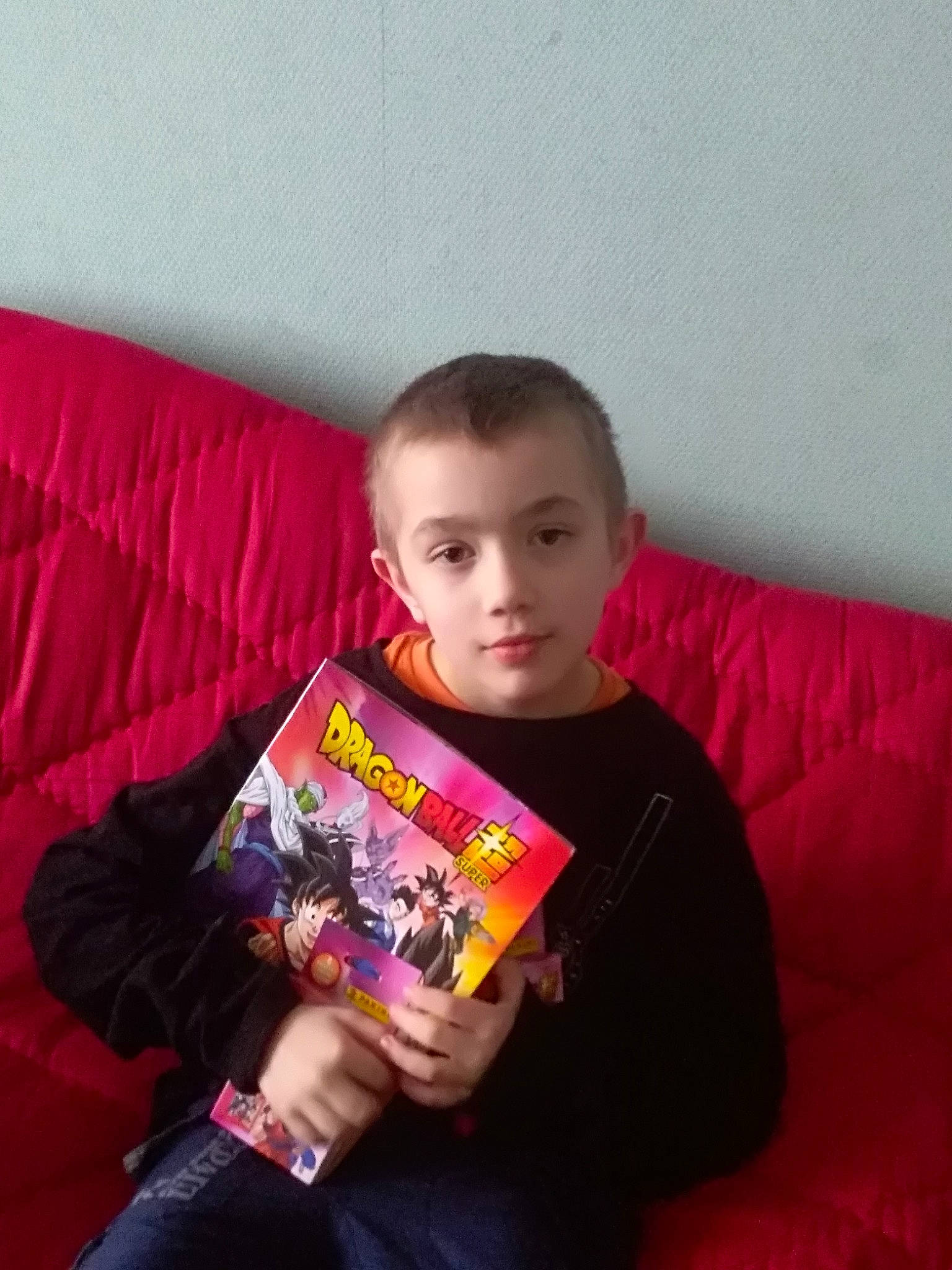 Simon a rejoint le concours — aidez-le/la à gagner de superbes lots ! book, child, comfort, couch, finger, fun, gadget, hand, linens, magenta, person, pillow, play, publication, reading, room, sitting, sleeve, t_shirt, throw_pillow