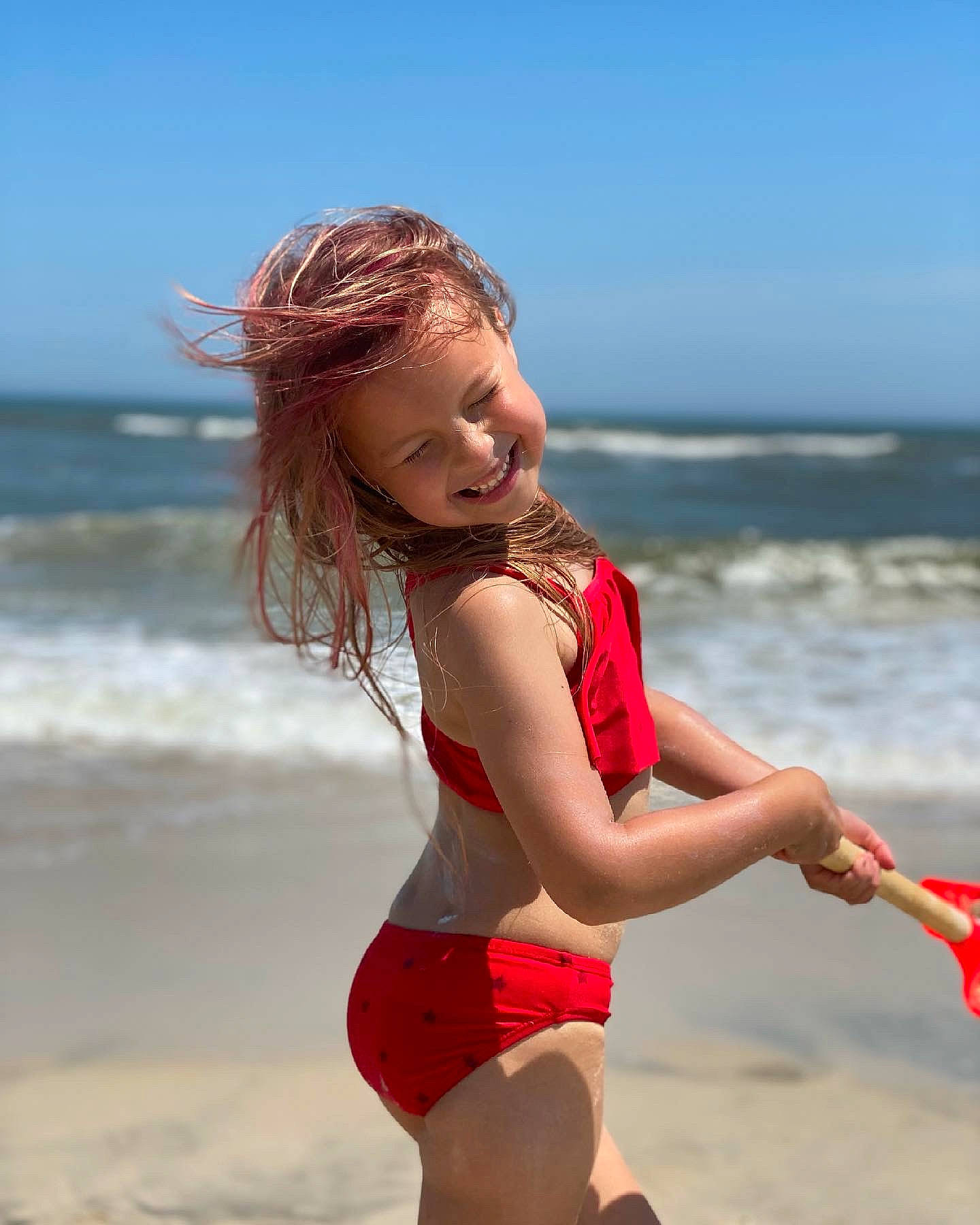 Sofia is registered to the contest to win money with this photo: beach, beauty, coastal_and_oceanic_landforms, flash_photography, fun, hair, hairstyle, happy, joy, knee, long_hair, people_in_nature, people_on_beach, person, shorts, sky, smile, summer, sunlight, thigh