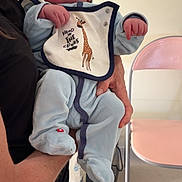 Mylan participe au concours pour gagner de l'argent avec cette photo : baby, child, infant, person, holding, onesie, hat, bib, giraffe, indoor, chair, arm, clothing, poster, wall, floor, pink_chair, hand, cute, newborn