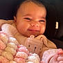 Alayah is registered to the contest to win money with this photo: baby, smiling, blanket, pink, white, knitted, infant, cute, face, hand, seat, cushion, clothing, cozy, soft, portrait, indoors, child, warm, happy