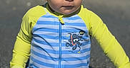 Noah is registered to the contest to win money with this photo: child, toddler, baby, portrait, beach, water, swimwear, rash_guard, striped_clothing, octopus, outdoor, sunlight, wet, sitting, serious_expression, short_hair, ocean, summer, face, black_border