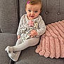 toddler, child, sofa, pink_hair_clip, blue_eyes, grey_sofa, pink_pillow, cross_legged, starfish_applique, cozy_clothing, indoor, cute, smiling, young_child, plush_pillow, home_interior, sitting, person, portrait, casual
