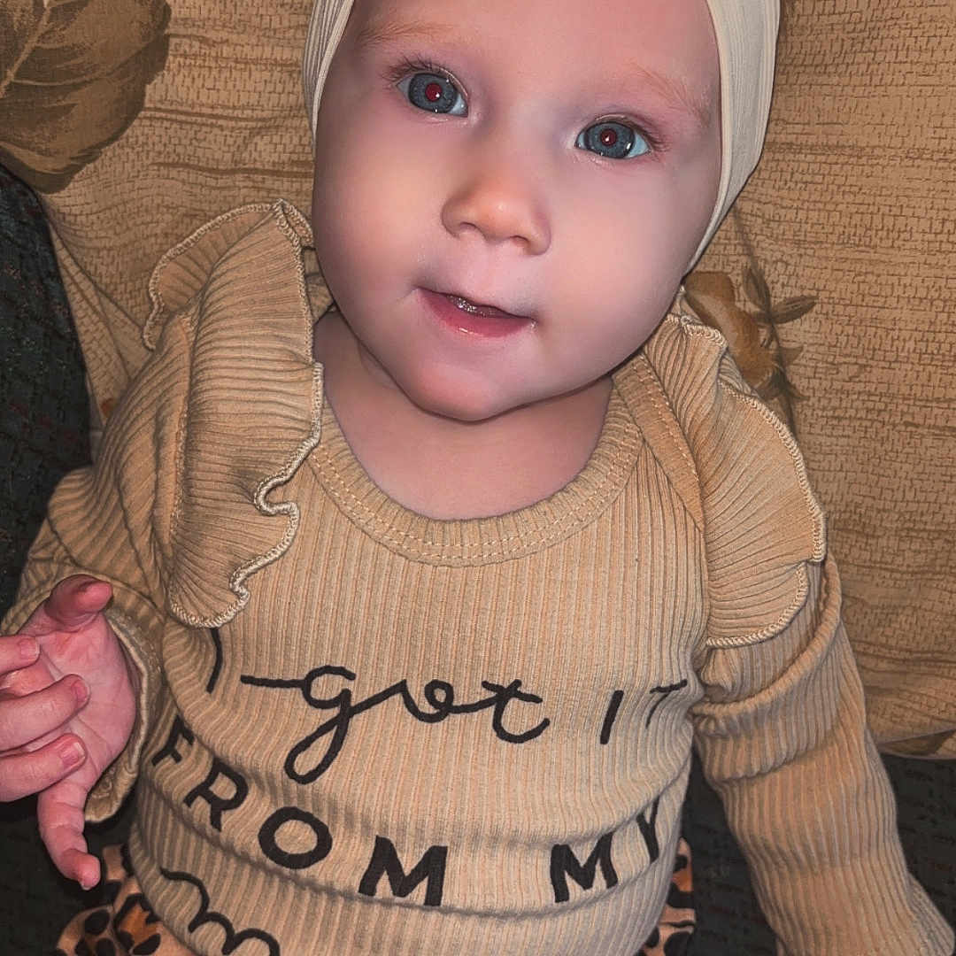 Oakleigh joined the competition — help win amazing prizes! child, toddler, headband, bow, leopard_print, pants, shirt, beige, ruffles, sitting, couch, textured, pattern, smile, face, curious, indoors, baby, clothing, portrait
