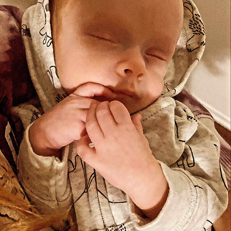 Chess is registered to the contest to win money with this photo: baby, baby_products, baby_toddler_clothing, camouflage, cheek, child, comfort, ear, gesture, hand, happy, lip, military_camouflage, mouth, nose, pattern, skin, sleeve, thumb, toddler