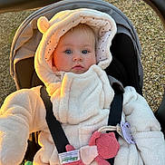 Jade a rejoint le concours — aidez-le/la à gagner de superbes lots ! baby, infant, stroller, onesie, hood, fuzzy_clothing, blue_eyes, pacifier, toy, straps, outdoor, sunlight, golden_hour, cute, child, face, person, winter_clothing, warm, soft