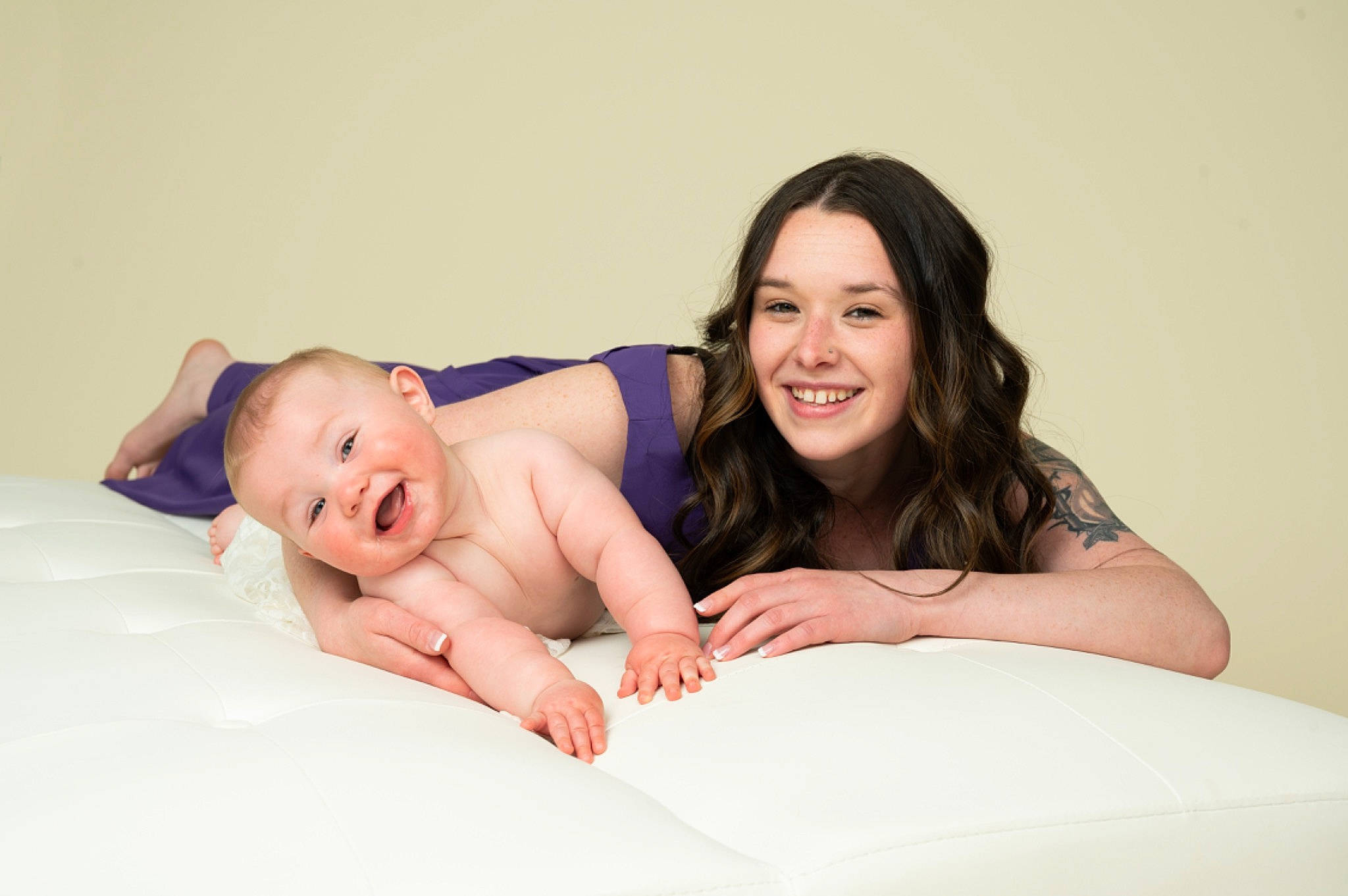 Deegan is registered to the contest to win money with this photo: arm, baby, bedding, comfort, event, flash_photography, fun, gesture, happy, interaction, joy, laugh, leisure, linens, person, portrait_photography, room, sitting, skin, smile
