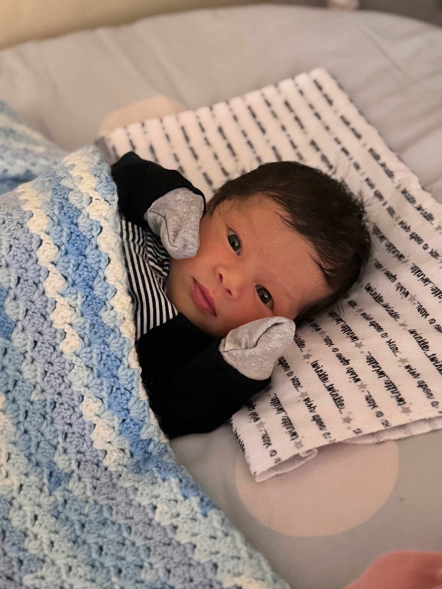 Nirvana joined the competition — help win amazing prizes! newborn, baby, blanket, crochet, pillow, mittens, face, infant, lying_down, striped_clothing, bed, soft, cute, indoors, portrait, sleeping_area, cozy, tiny_hands, resting, young_child