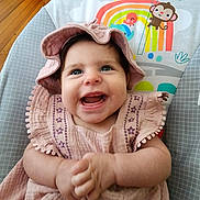 Isadora joined the competition — help win amazing prizes! baby, child, smiling, pink_dress, hat, baby_chair, rainbow, monkey, sun, indoor, wooden_floor, happy, cute, portrait, infant, clothing, colorful, playful, hands, seat
