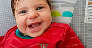 Isadora is registered to the contest to win money with this photo: baby, child, smiling, red_shirt, soccer_jersey, portugal, indoors, colorful_background, rainbow, monkey_illustration, happy, cute, portrait, face, head, sitting, closeup, infant, clothing, person