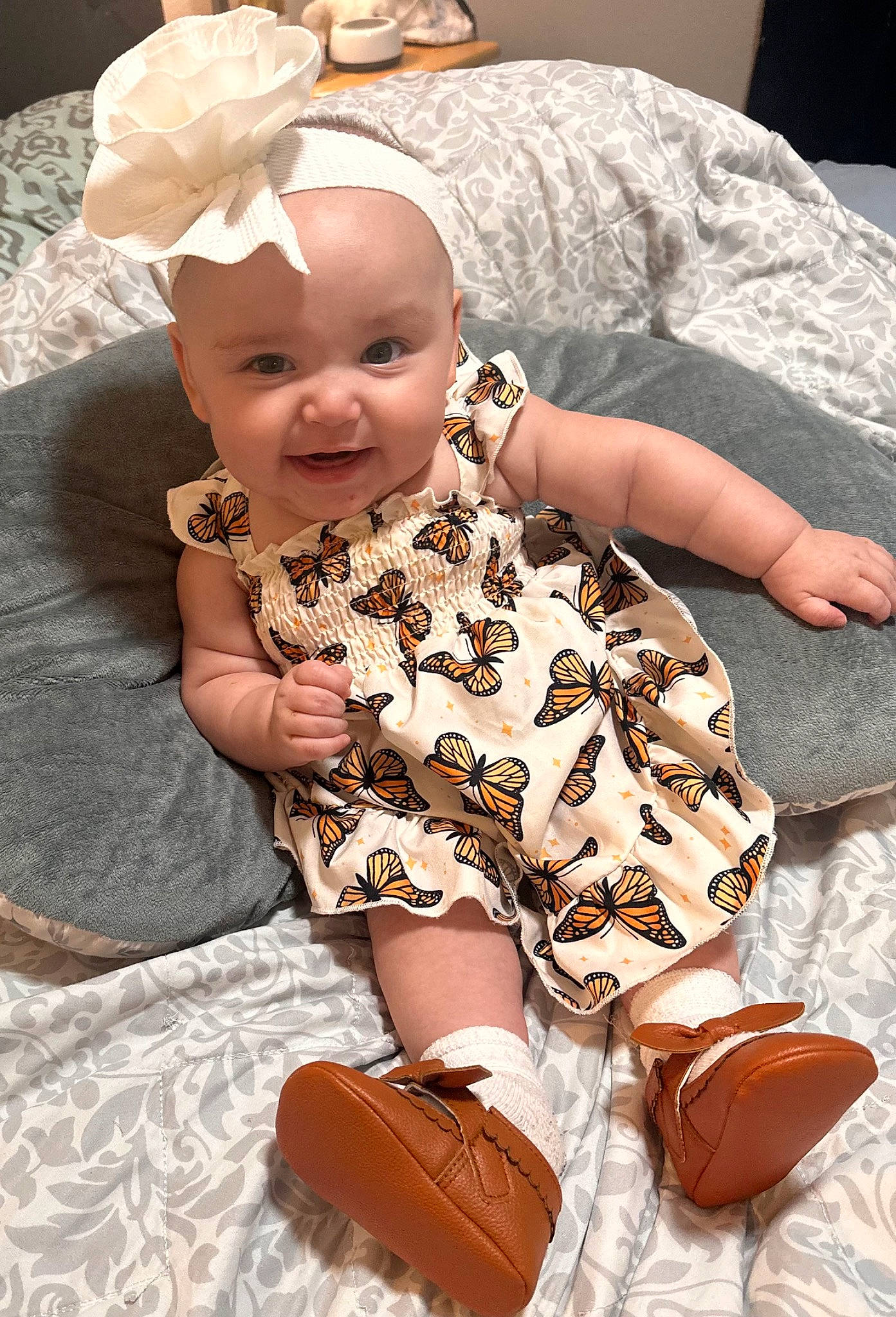 Jojo is registered to the contest to win money with this photo: baby, baby_products, baby_toddler_clothing, bag, child, comfort, event, fashion_accessory, flooring, fun, happy, human_leg, joy, luggage_and_bags, pattern, peach, person, sitting, sleeve, smile
