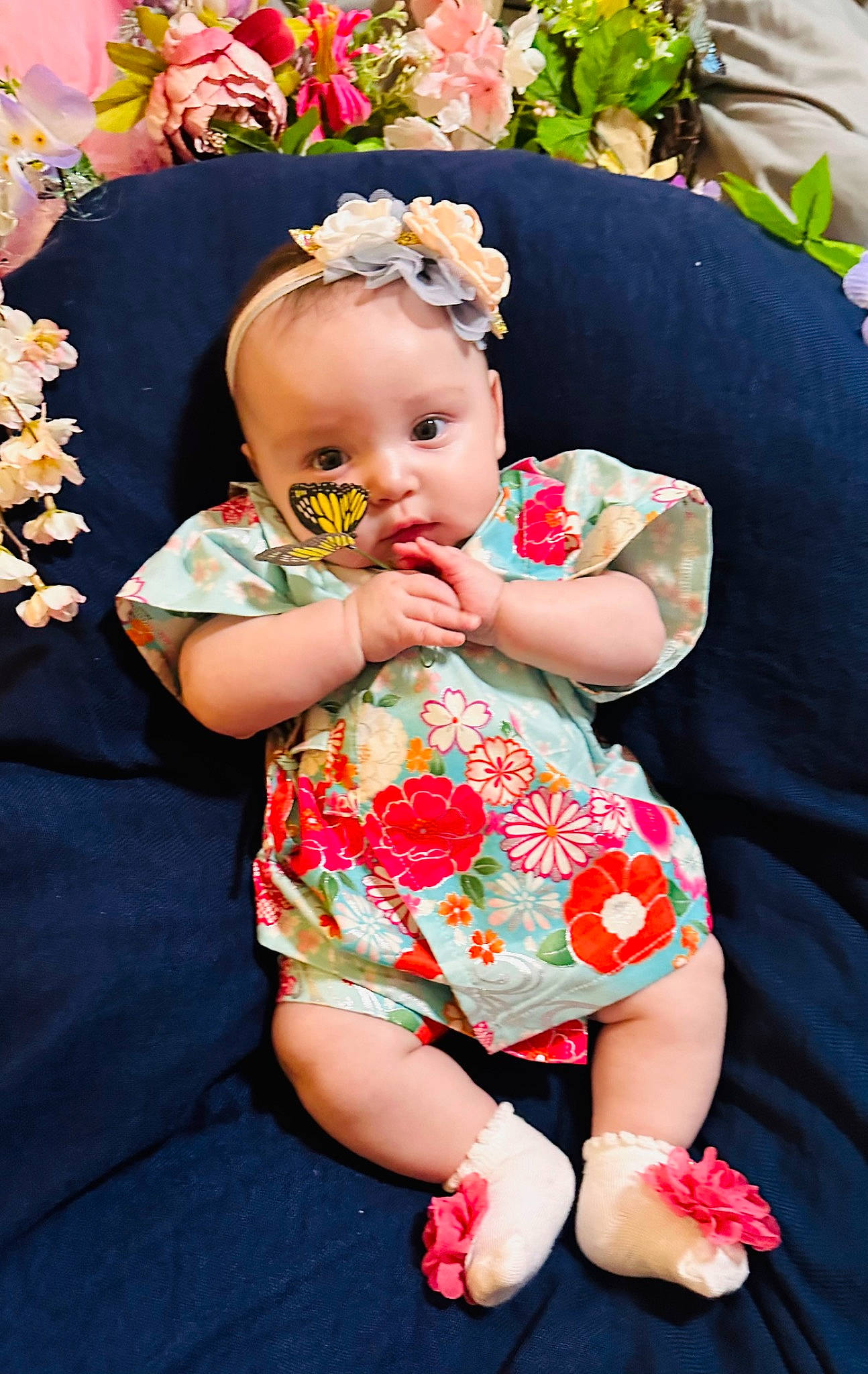 Jojo is registered to the contest to win money with this photo: baby, baby_toddler_clothing, child, dress, event, eye, fun, grass, hairstyle, happy, head, iris, pattern, person, pink, plant, sitting, skin, textile, thigh