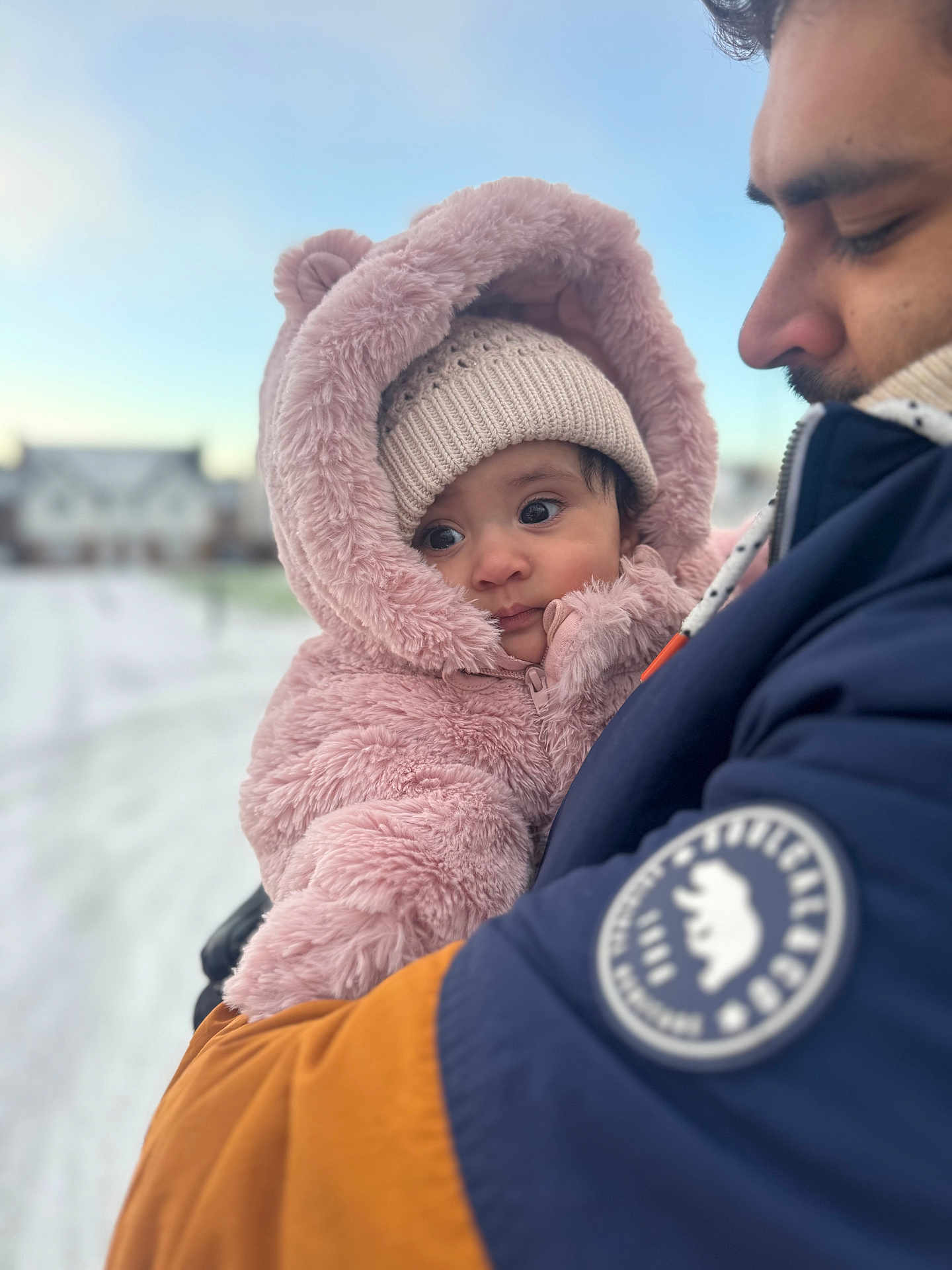 Hira is registered to the contest to win money with this photo: baby, child, adult, winter_clothing, pink_fur, beanie, jacket, snow, outdoor, portrait, holding, cold_weather, face, person, warm_clothing, close_up, family, cute, cozy, daylight
