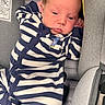baby, car_seat, child, clothing, cream, eyes, face, indoor, infant, navy_blue, newborn, padding, photography, portrait, relaxed, safety_label, sitting, sleepy, striped_outfit, vehicle