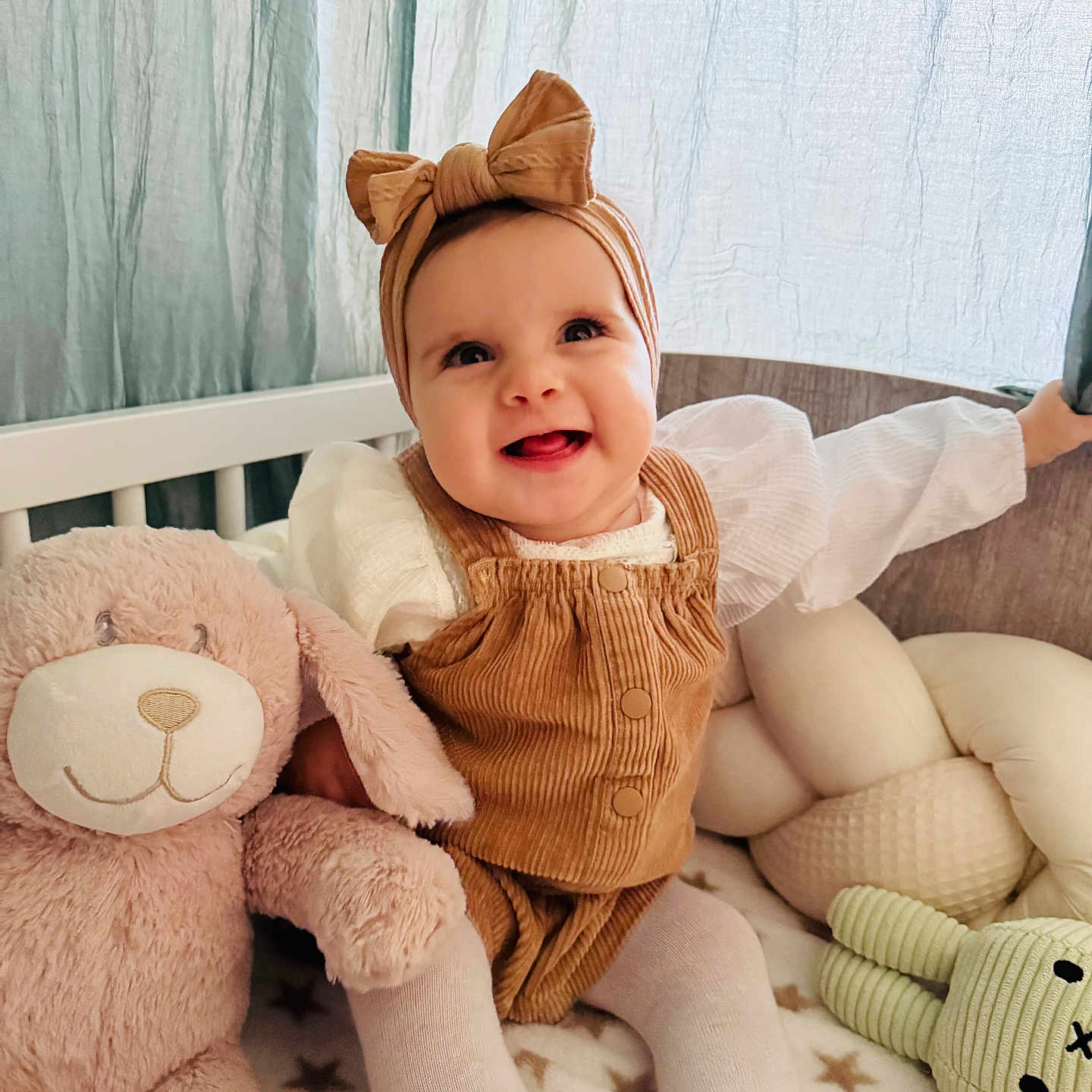 Alma-Maria a rejoint le concours — aidez-le/la à gagner de superbes lots ! baby, blanket, bow, bunny, child, corduroy, crib, curtains, cute, happy, headband, indoors, infant, person, plush_toy, seated, smiling, soft_light, tights, toy