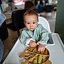 Nino a rejoint le concours — aidez-le/la à gagner de superbes lots ! baby, high_chair, food, plate, snack, turtle_shaped_plate, bib, indoor, child, curious, blue_eyes, hand, table, furniture, person, cute, small, feeding, home, eating