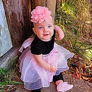 Jade joined the competition — help win amazing prizes! baby, child, girl, smiling, headband, pink_flower, dress, black_top, tutu_skirt, sitting, outdoor, grass, leaves, fence, wooden_post, concrete, cute, portrait, footwear, happy