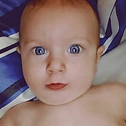 Cannon joined the competition — help win amazing prizes! baby, close_up, face, blue_eyes, skin, expression, curious, infant, portrait, child, lying_down, blanket, striped, human, head, young, cute, indoors, soft_light, person