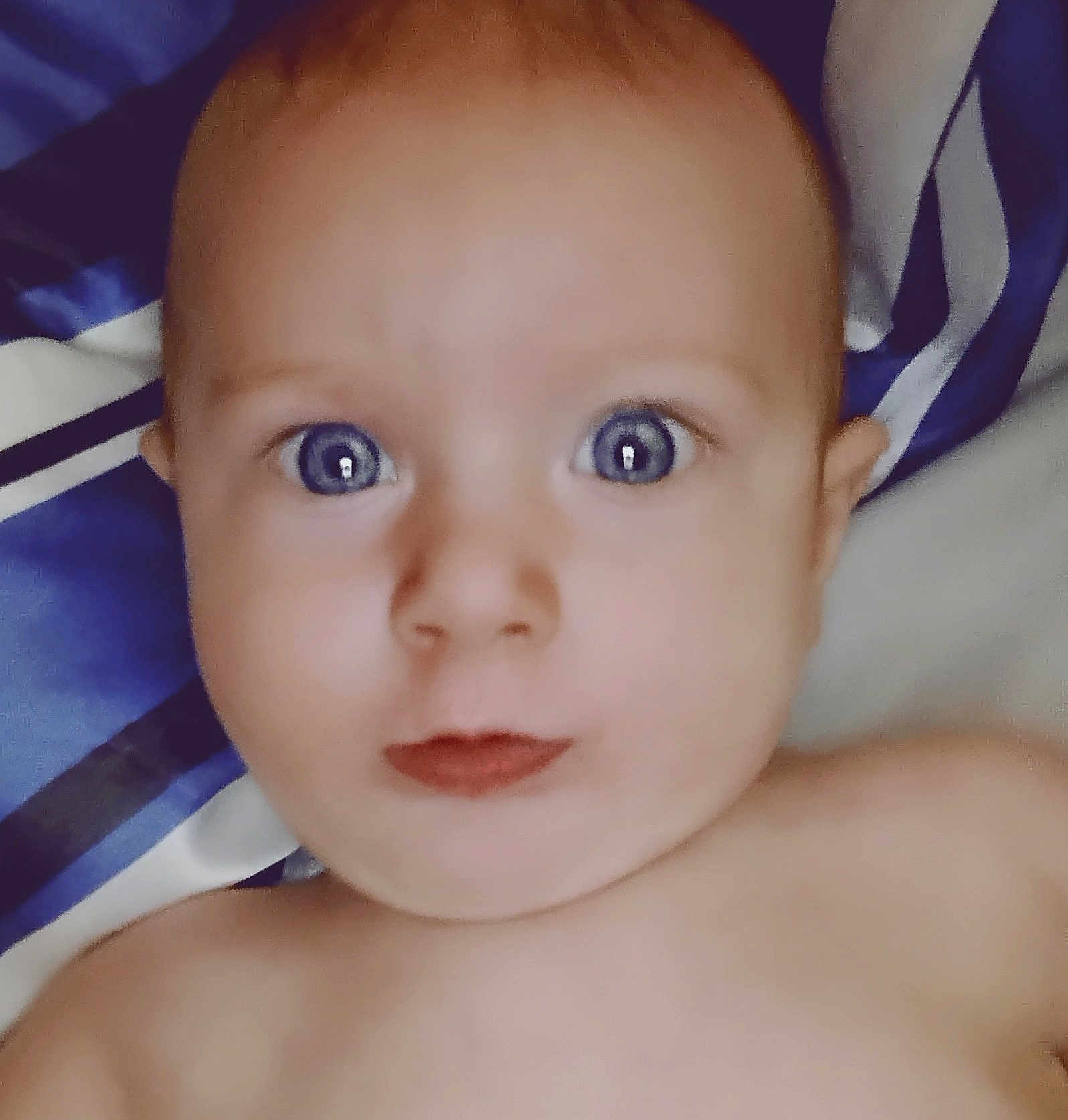 Cannon joined the competition — help win amazing prizes! baby, close_up, face, blue_eyes, skin, expression, curious, infant, portrait, child, lying_down, blanket, striped, human, head, young, cute, indoors, soft_light, person