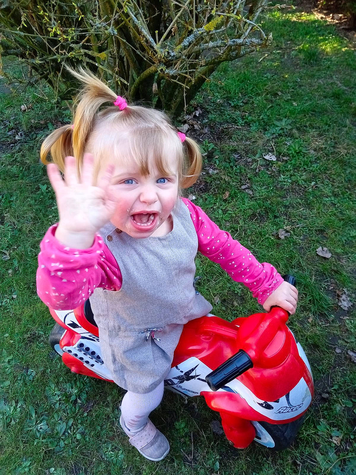 Anastasia participe au concours pour gagner de l'argent avec cette photo : baby, baby_toddler_clothing, carmine, child, fun, grass, happy, lawn, magenta, people_in_nature, person, pink, plant, recreation, riding_toy, sitting, smile, toddler, toy, tree