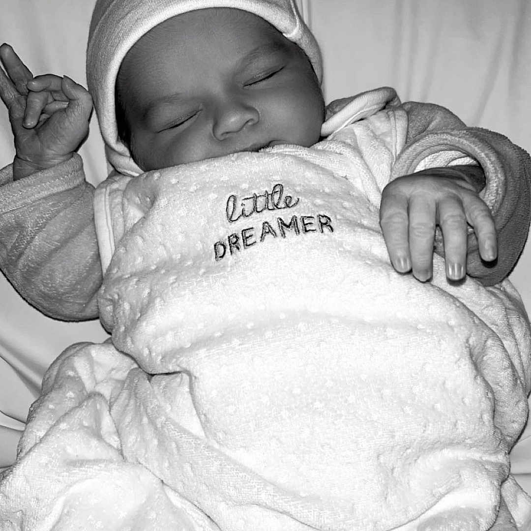 Tylianna participe au concours pour gagner de l'argent avec cette photo : baby, bed, blanket, child, clothing, cozy, cute, fabric, face, hand, hat, infant, monochrome, newborn, peaceful, portrait, resting, sleeping, soft, wrapped