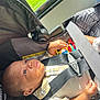 Nymir is registered to the contest to win money with this photo: baby, car_seat, seatbelt, plaid_shirt, toy, sunlight, window, infant, child, safety, seat, clothing, hand, face, portrait, indoor, child_seat, belt, person, young_child