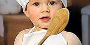 Zao participe au concours pour gagner de l'argent avec cette photo : apron, baby, bread, bright_eyes, chef_hat, child, cooking, cooking_utensil, cute, face, food, hand, indoor, kitchen, person, portrait, smiling, table, wooden_spoon, young_child