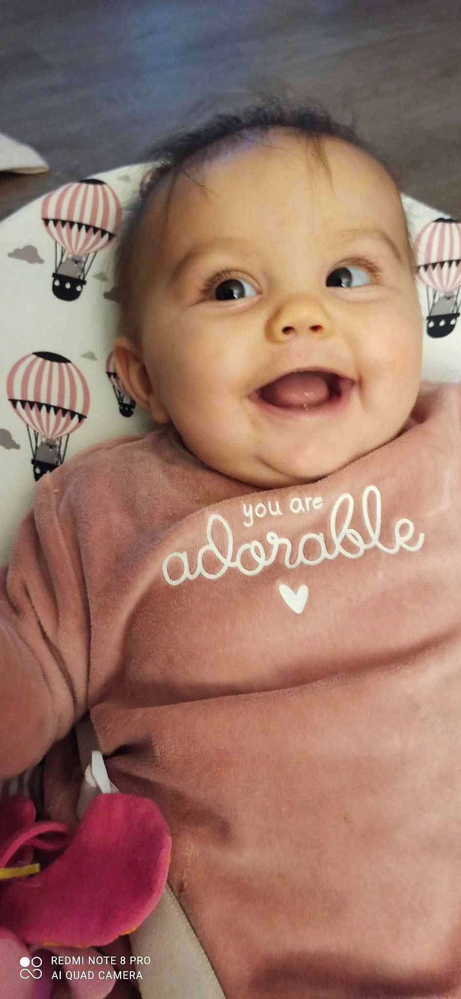 Kelsy a rejoint le concours — aidez-le/la à gagner de superbes lots ! baby, baby_laughing, baby_toddler_clothing, cheek, chest, eyebrow, eyelash, finger, font, gesture, happy, joy, kitchen_utensil, neck, nose, person, pink, skin, smile, thumb