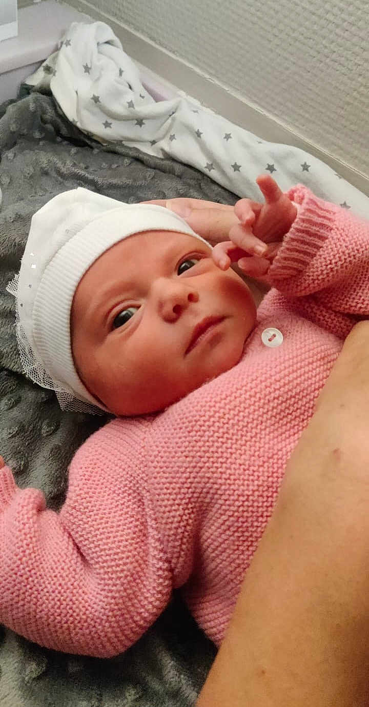 Lou participe au concours pour gagner de l'argent avec cette photo : newborn, baby, infant, pink_sweater, white_hat, blanket, cozy, arm, hand, face, lying_down, indoor, soft_texture, knitted, cute, child, person, portrait, skin, resting
