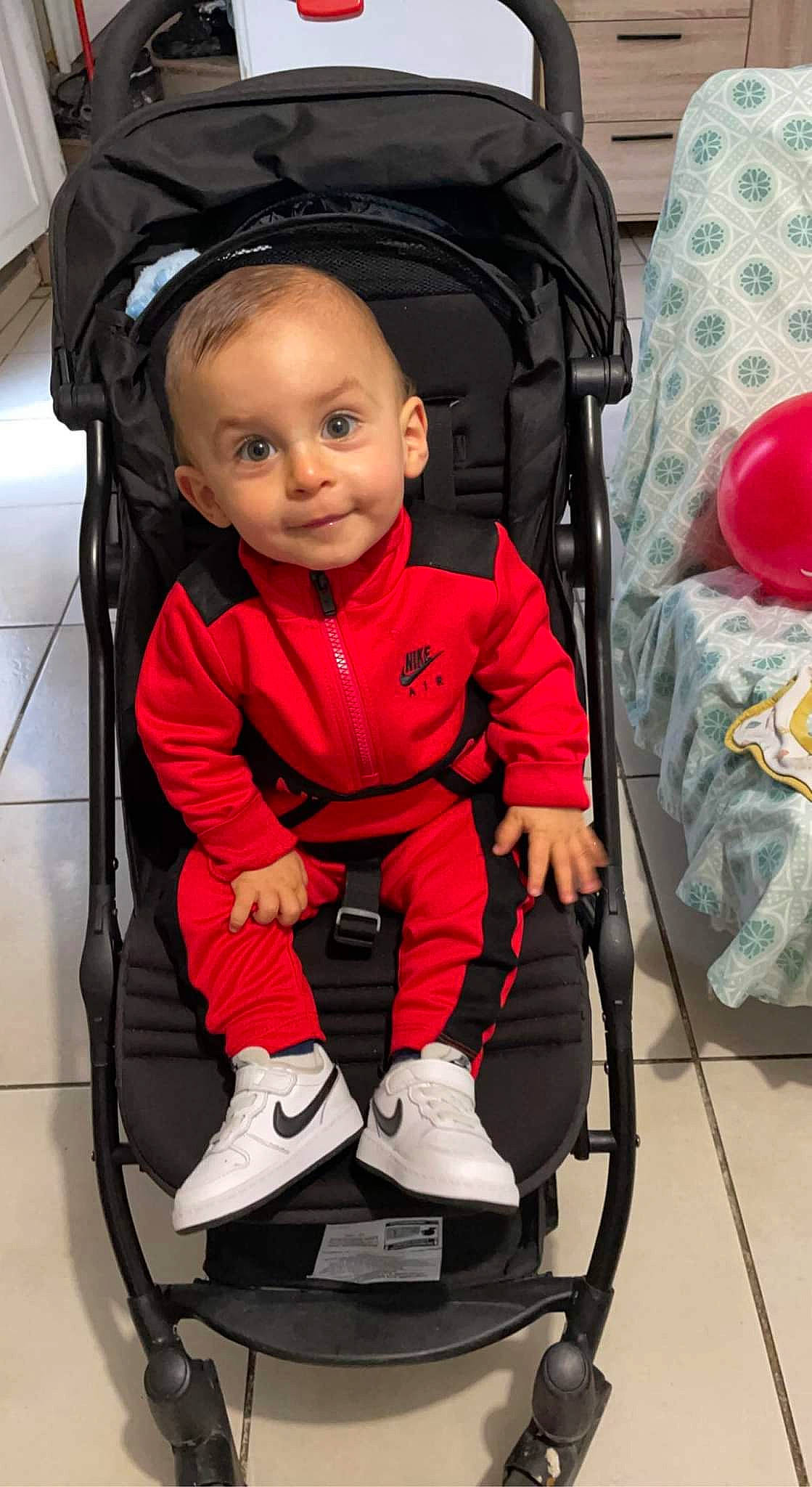 Mayron a rejoint le concours — aidez-le/la à gagner de superbes lots ! baby, baby_carriage, baby_products, baby_safety, baby_toddler_clothing, balloon, beauty, child, comfort, eye, face, fashion_accessory, fun, magenta, person, photograph, red, sitting, smile, snapshot