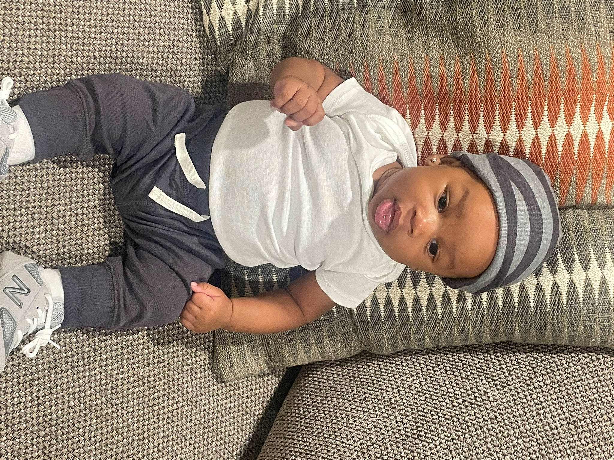 Kartier is registered to the contest to win money with this photo: baby, baby_toddler_clothing, child, comfort, elbow, fence, flooring, foot, fun, hand, headwear, human_body, human_leg, knee, pattern, person, smile, sock, sunglasses, thigh