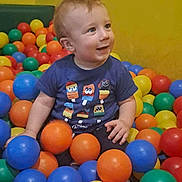 Warren participe au concours pour gagner de l'argent avec cette photo : toddler, child, ball_pit, colorful_balls, blue_shirt, smiling, indoor, play_area, yellow_wall, happy, sitting, short_hair, casual_clothing, cute, fun, playful, person, young_child, toy, plastic_balls