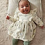 Lyianna participe au concours pour gagner de l'argent avec cette photo : baby, infant, smiling, tongue_out, lying_down, pillow, fluffy_rug, dress, floral_pattern, leggings, cute, happy, child, indoors, soft_texture, playful, small_hands, small_feet, portrait, light_colors