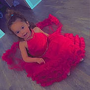 Tayana participe au concours pour gagner de l'argent avec cette photo : celebration, child, curly_hair, cute, earrings, fashion, flooring, frilly_dress, girl, hair_tie, happy, home, indoor, person, playful, portrait, red_dress, sitting, smiling, wooden_floor