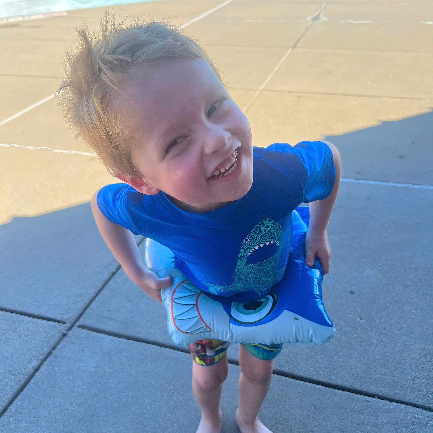 Korban is registered to the contest to win money with this photo: amusementpark, baby, barefoot, clothing, face, footwear, head, outdoors, pants, person, photography, pool, portrait, sandal, shorts, summer, swimmingpool, t_shirt, water, waterpark