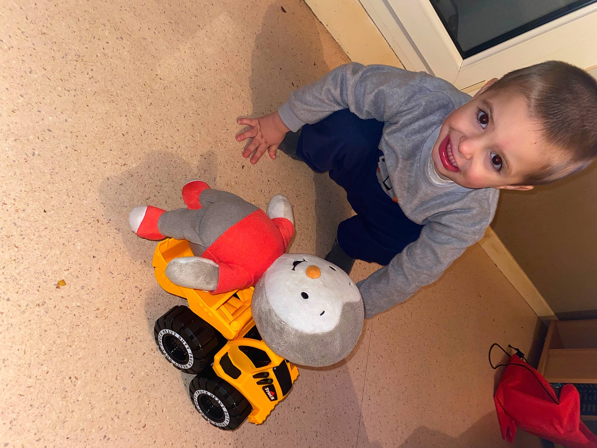 Hayden participe au concours pour gagner de l'argent avec cette photo : baby, baby_toddler_clothing, baby_toys, backpack, bag, carmine, child, floor, flooring, fun, joy, luggage_and_bags, machine, person, play, room, sitting, tire, toddler, toy