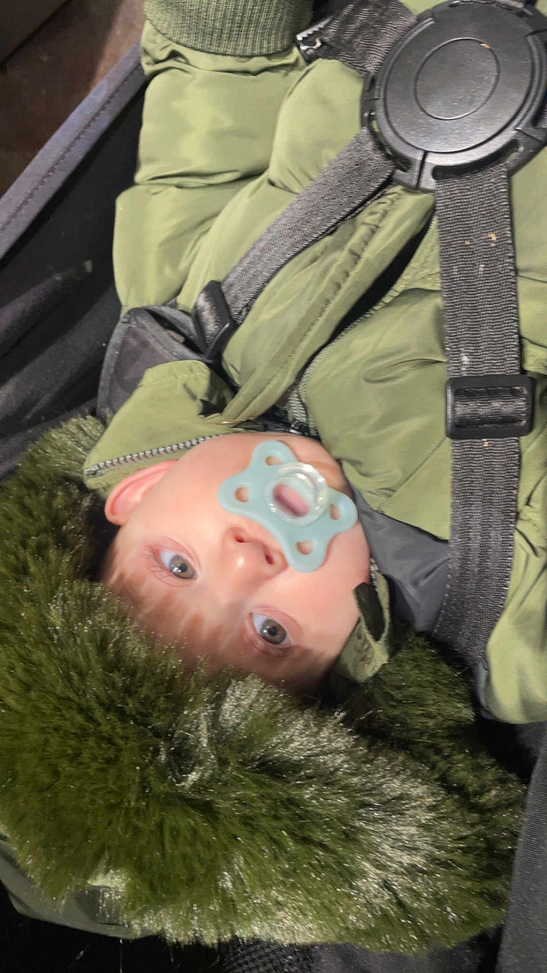 Yllan participe au concours pour gagner de l'argent avec cette photo : baby, child, pacifier, jacket, green_jacket, fur_hood, face, eyes, infant, warm_clothing, seat_belt, car_seat, close_up, winter_clothing, straps, child_seat, portrait, cute, indoors, young
