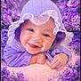Iris is registered to the contest to win money with this photo: baby, blossoms, child, closeup, cute, cute_outfit, floral, flowers, hands, happy, hood, infant, lying_down, nature, pastel, portrait, purple, skin, smiling, soft