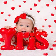 Iris joined the competition — help win amazing prizes! baby, balloon_letters, celebration, child, closeup, cute, happy, headband, hearts, holiday, indoor, infant, joyful, love_theme, playful, portrait, red_bow, red_color, smiling, soft_background