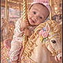 Iris joined the competition — help win amazing prizes! amusement_park, baby, carousel, carousel_horse, child, cute, decorative, festive, festivity, flower, golden_pole, happy, indoor, pastel_colors, pink_headband, playful, portrait, ride, smiling, toy_horse