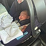 baby, car_seat, blanket, infant, sleeping, child, safety_harness, vehicle_interior, seat, cozy, peaceful, portrait, child_seat, car, newborn, clothing, soft_light, resting, cute, travel